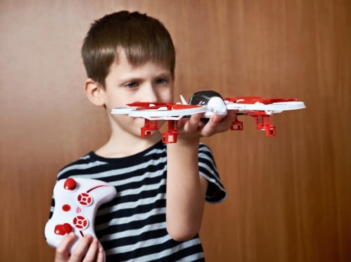 are drones safe for kids? Kid holding drone under $50